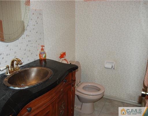 5 Chandler Road Edison, NJ 08820 - Photo 17 of 23 a bathroom with a sink a toilet and a mirror