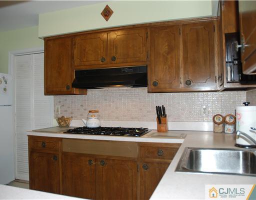 5 Chandler Road Edison, NJ 08820 - Photo 8 of 23 a kitchen with granite countertop cabinets and black appliances