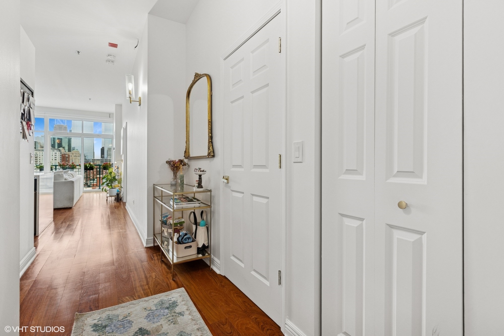 340 West Superior Street, Unit 1607 Chicago, IL 60654 - Photo 6 of 17 a hallway with white doors wooden floor and a table
