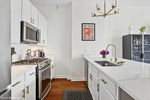 a kitchen with stainless steel appliances granite countertop a sink stove and a microwave
