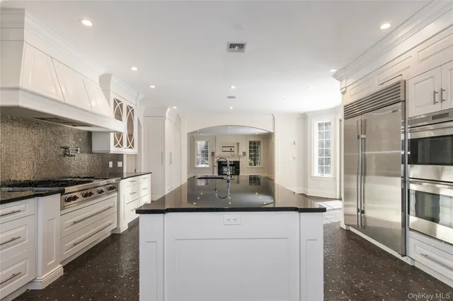 a kitchen with stainless steel appliances granite countertop a stove a sink and a refrigerator