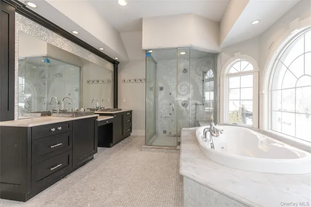 a spacious bathroom with a tub sink shower and mirror