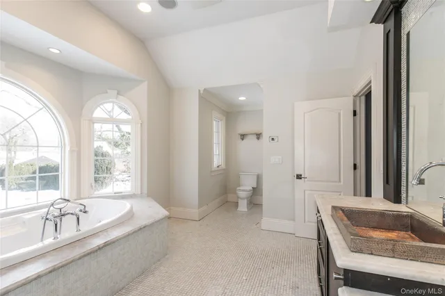 a spacious bathroom with a tub and 2 sink