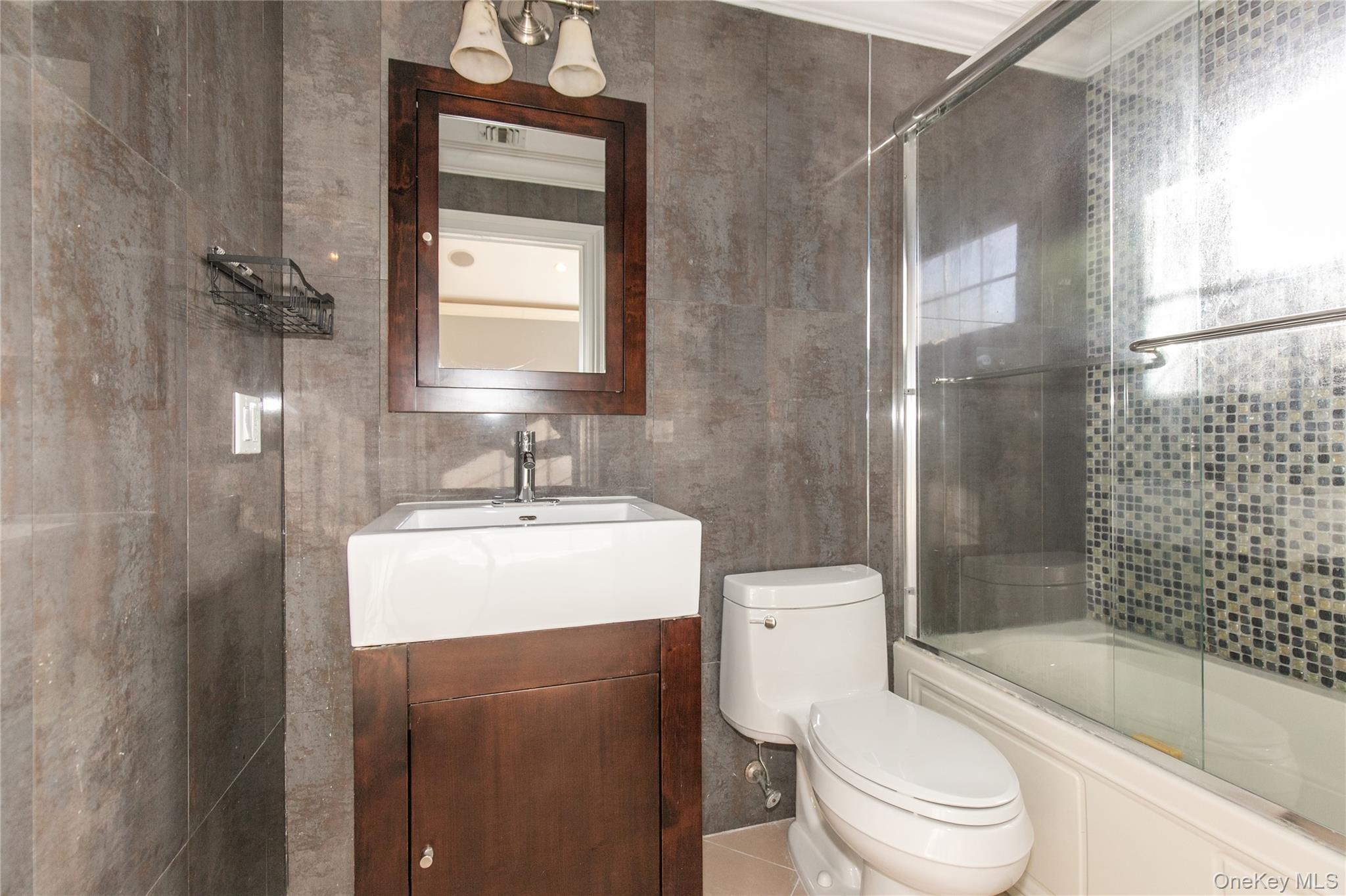 12 Knollwood Road Roslyn, NY 11576 - Photo 27 of 41 a bathroom with a sink toilet and shower