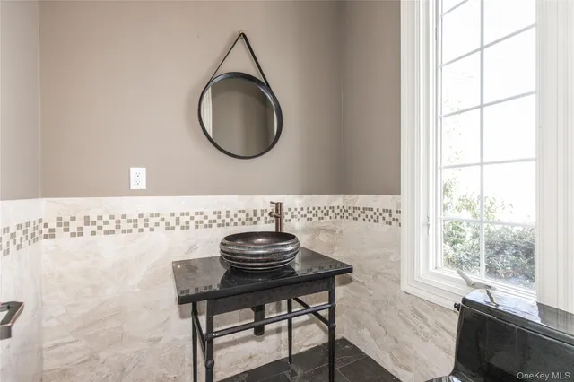 a bathroom with a sink a mirror and a window