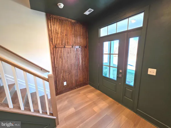 a view of an empty room with wooden floor and windows