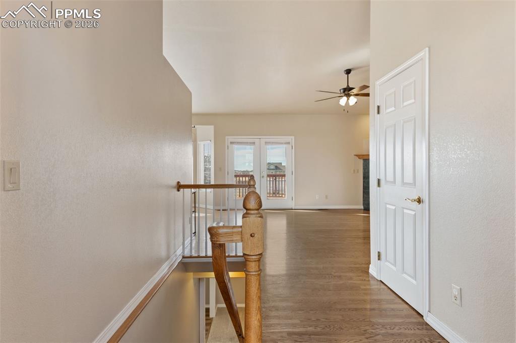 11515 Texarkanna Road Peyton, CO 80831 - Photo 11 of 43 Corridor featuring an upstairs landing, light wood-style flooring, french doors, and a textured wall