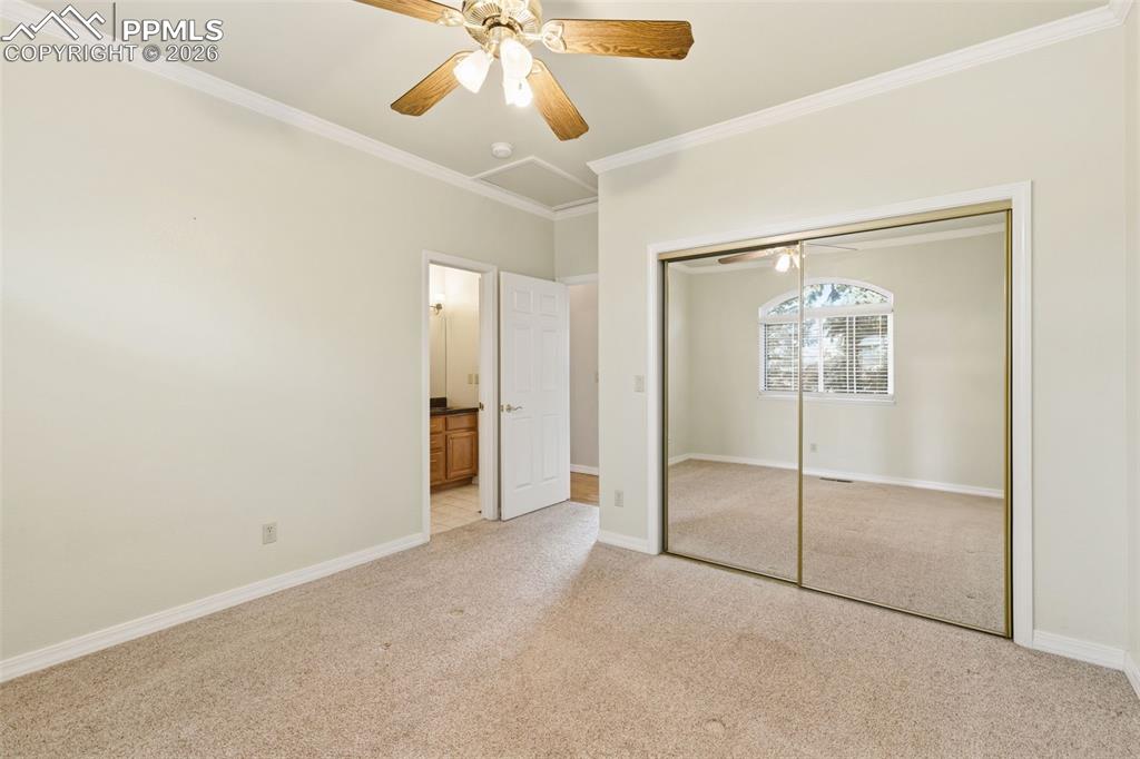 11515 Texarkanna Road Peyton, CO 80831 - Photo 29 of 43 Unfurnished bedroom with crown molding, light carpet, a closet, a ceiling fan, and ensuite bathroom
