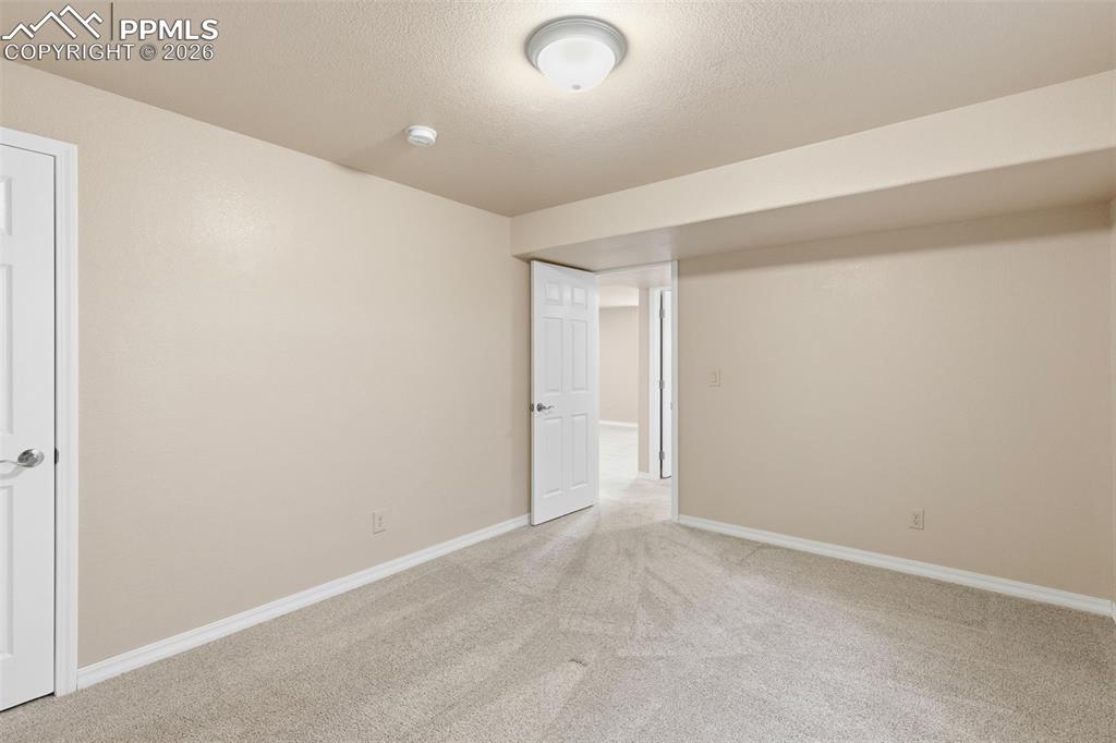 11515 Texarkanna Road Peyton, CO 80831 - Photo 44 of 49 Empty room with light carpet and a textured ceiling