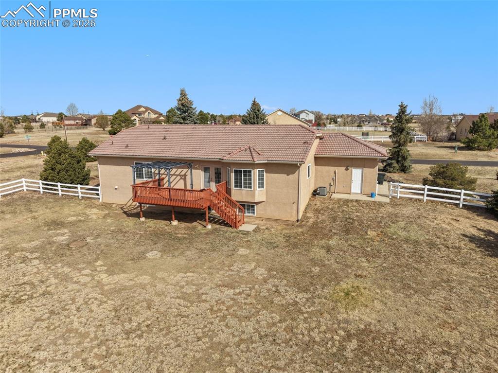 11515 Texarkanna Road Peyton, CO 80831 - Photo 7 of 43 Rear view of house with a fenced backyard, stucco siding, a tiled roof, and a deck