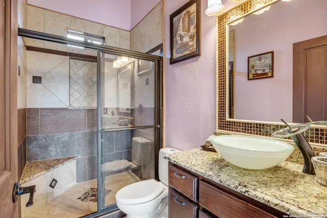 a bathroom with a granite countertop sink toilet and shower