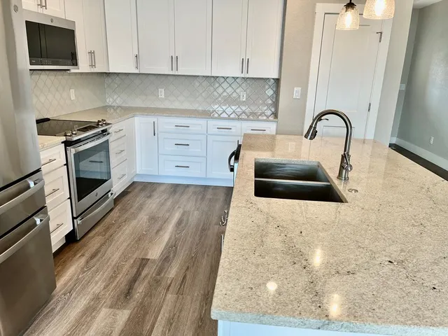 a kitchen with granite countertop a stove and a sink