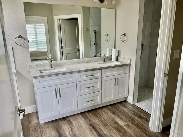 a bathroom with a granite countertop sink and a mirror