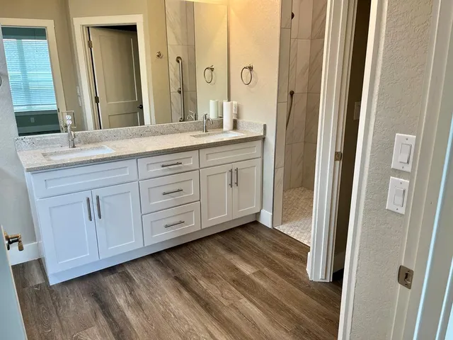 a bathroom with a granite countertop sink and a mirror