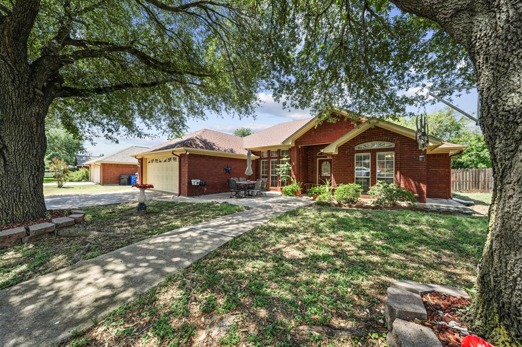 10127 Cougar Ridge Parkway Waco, TX 76708 - Photo 1 of 33 Red brick exterior with white trim, a covered entry, an attached garage, a concrete driveway, and established landscaping