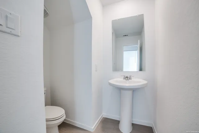 a bathroom with a sink a toilet and mirror