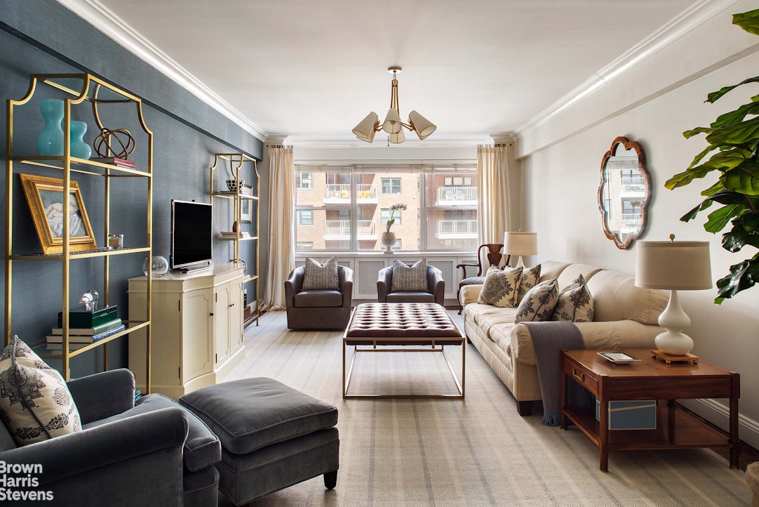 a living room with furniture a flat screen tv and a large window