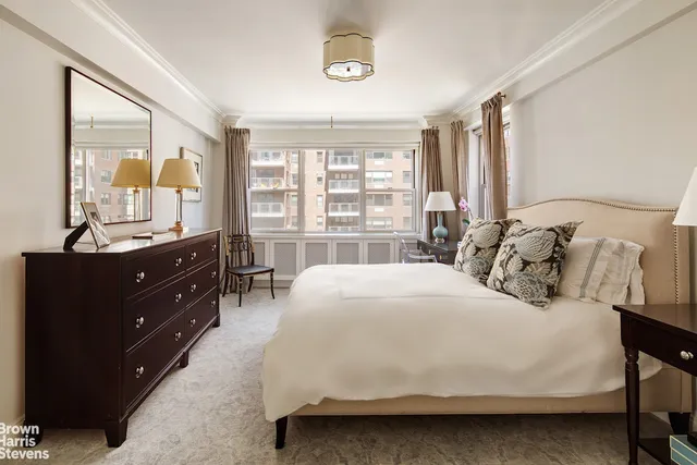 a bedroom with a bed and a large window