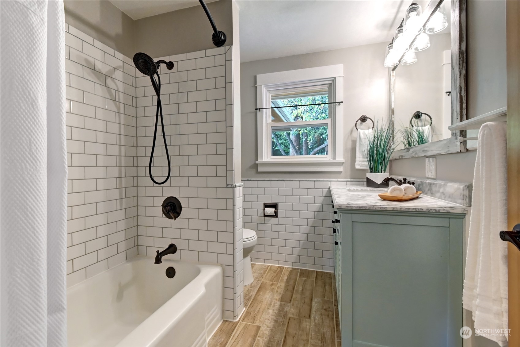 4041 48th Avenue Southwest Seattle, WA 98116 - Photo 14 of 28 a bathroom with a sink a mirror a bathtub and shower