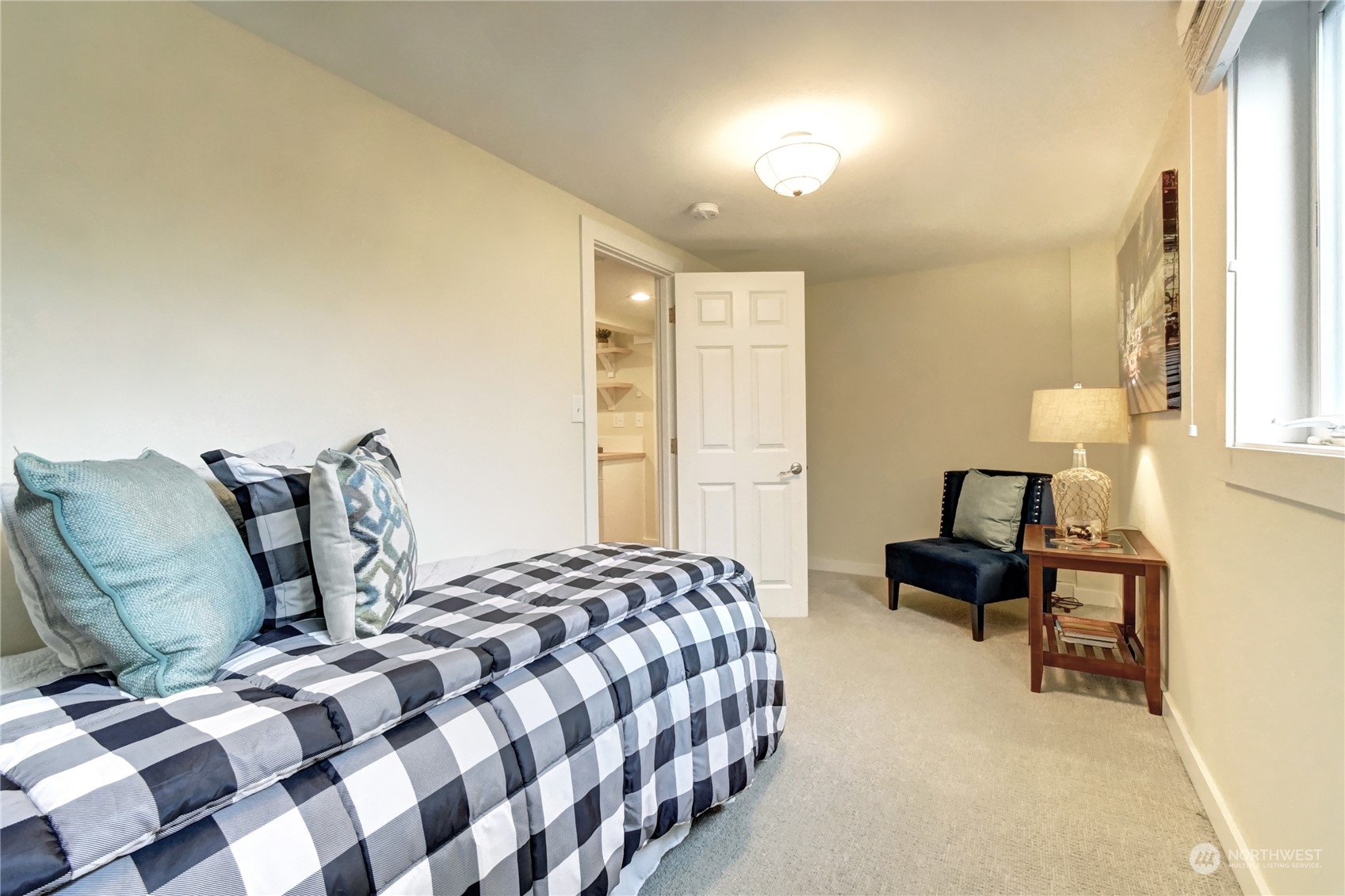 4041 48th Avenue Southwest Seattle, WA 98116 - Photo 18 of 28 a bedroom with a bed and wooden floor