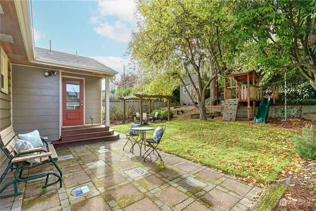 a view of a house with backyard and sitting area