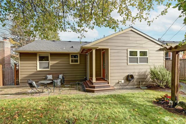 a backyard of a house with yard table and chairs