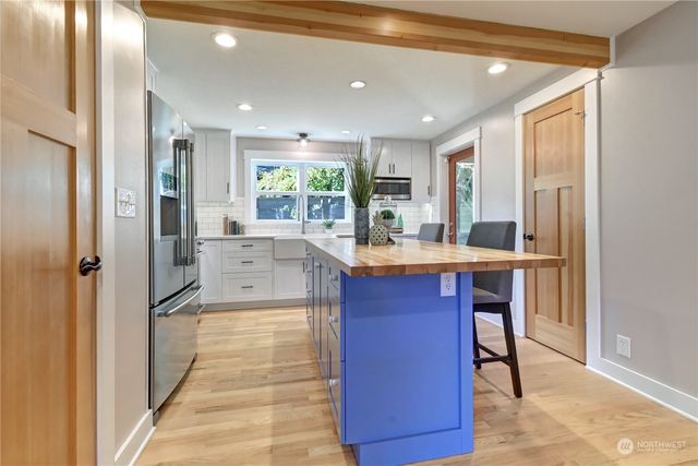 a open kitchen with stainless steel appliances granite countertop a refrigerator and a sink