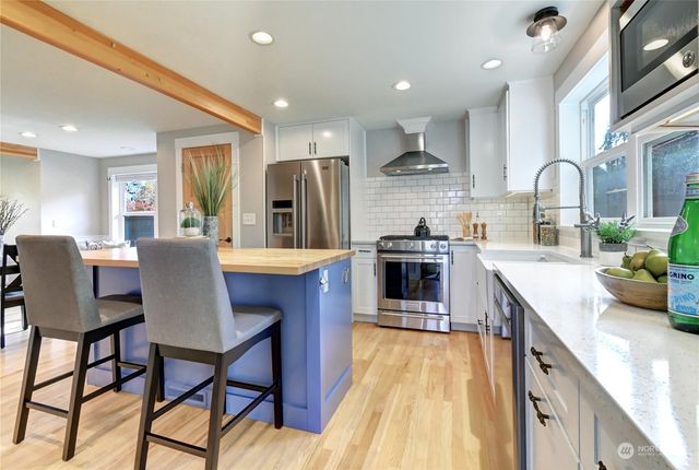 a kitchen with stainless steel appliances kitchen island granite countertop a sink and cabinets