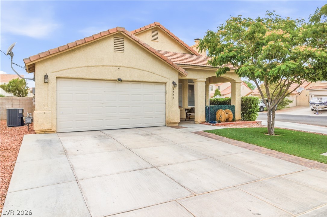 9523 Observer Street Las Vegas, NV 89123 - Photo 2 of 42 A welcoming front exterior showcasing a two-car garage and a shaded porch entry.