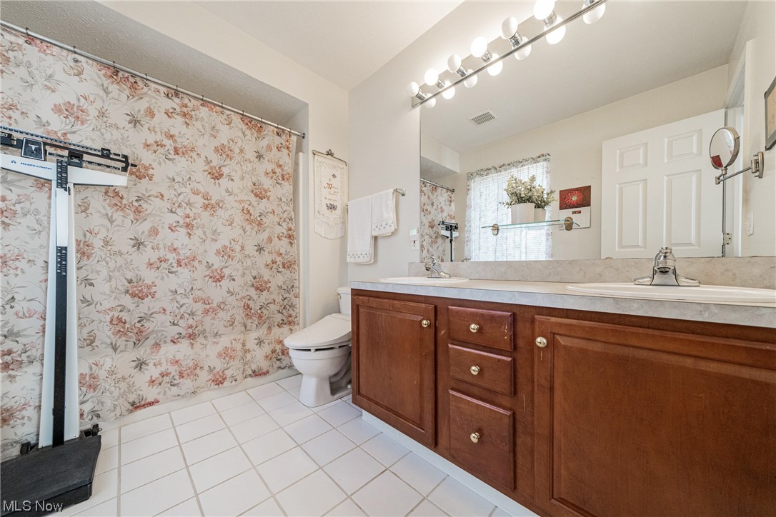 4220 Castle Ridge Akron, OH 44321 - Photo 14 of 35 Bathroom with large vanity, tile flooring, double sink, and toilet