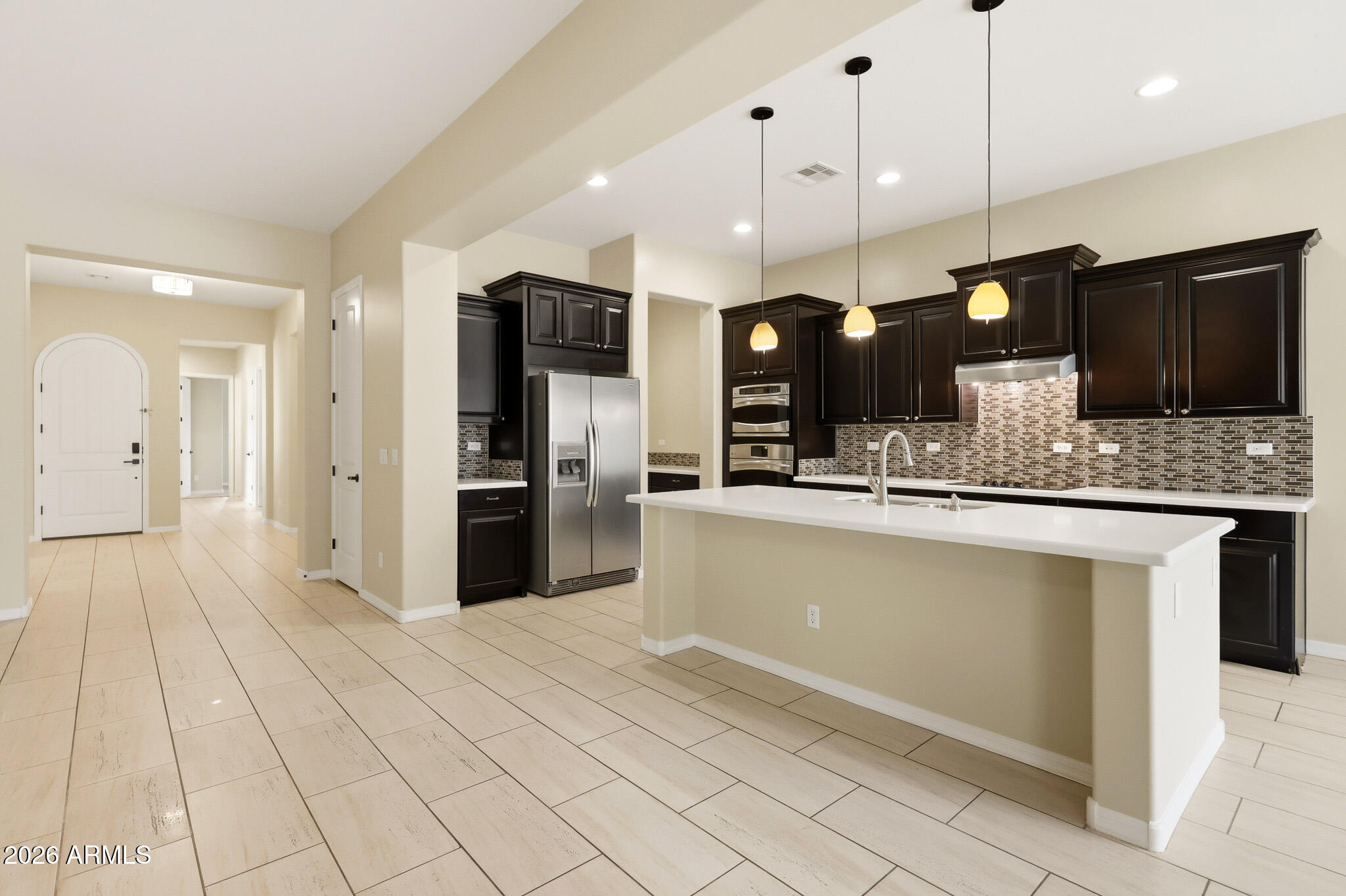 20441 West Hamilton Street Buckeye, AZ 85396 - Photo 15 of 88 a large kitchen with stainless steel appliances kitchen island granite countertop a refrigerator a sink and a stove
