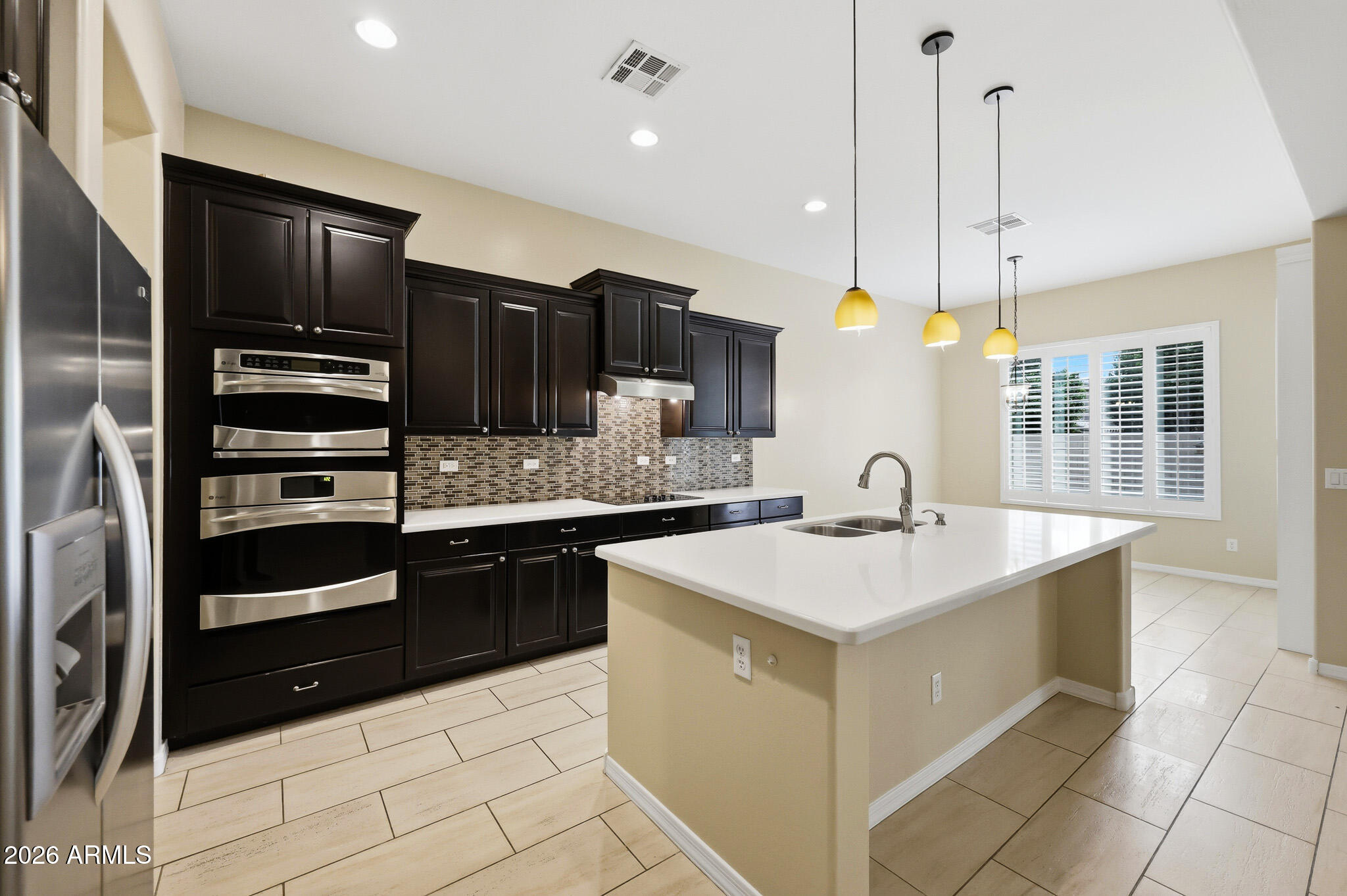 20441 West Hamilton Street Buckeye, AZ 85396 - Photo 19 of 88 a kitchen with a sink a stove and refrigerator