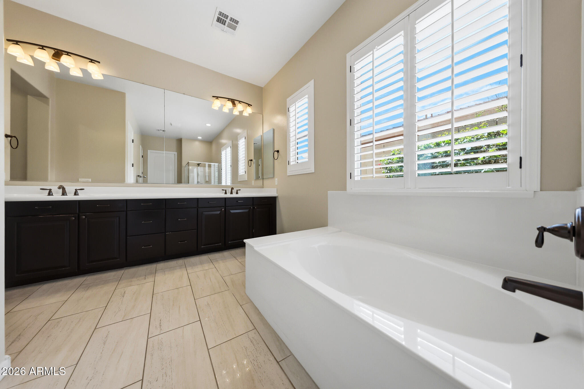 20441 West Hamilton Street Buckeye, AZ 85396 - Photo 29 of 88 a large spacious bathroom with a tub a double vanity sink a window and a mirror