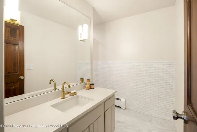 a bathroom with a sink a toilet and mirror