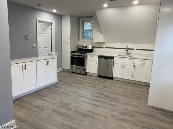 a kitchen with granite countertop white cabinets and white appliances