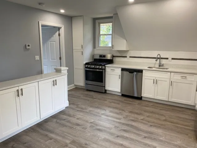 a kitchen with white cabinets and a stove