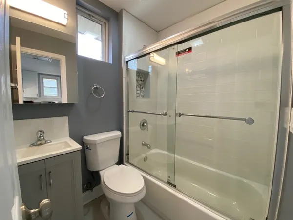 a bathroom with a shower a toilet and sink