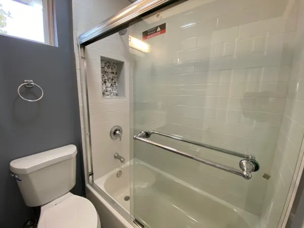 a bathroom with a toilet and a shower