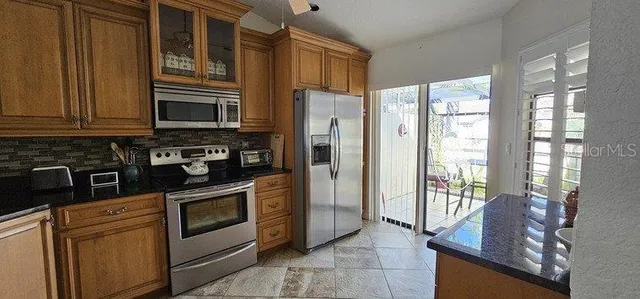 a kitchen with stainless steel appliances granite countertop a refrigerator oven stove a sink and dishwasher
