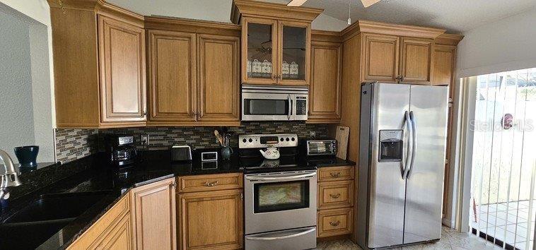 3920 Bal Harbor Boulevard, Unit E4 Punta Gorda, FL 33950 - Photo 6 of 24 a kitchen with stainless steel appliances granite countertop a refrigerator and a stove