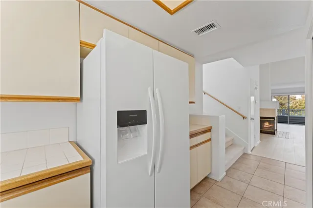 a hallway with white cabinets and white appliances