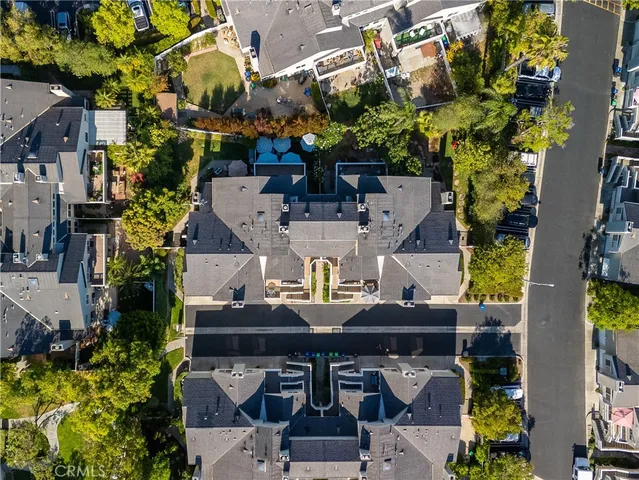 an aerial view of a residential houses with outdoor space and trees