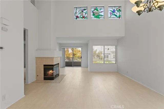 a view of an empty room with a fireplace and a window