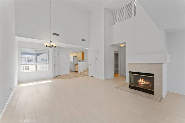 an empty room with windows and fireplace