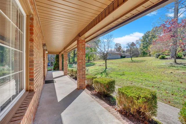 a view of a hallway with window and wooden floor