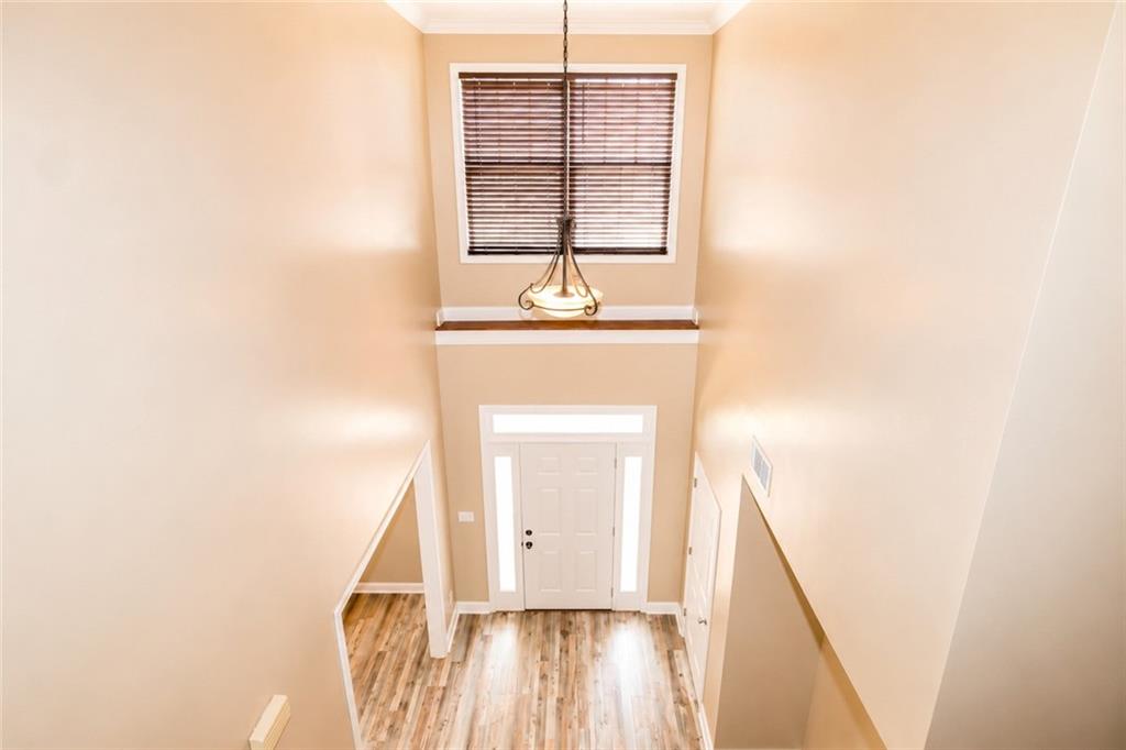 2078 Autumn Ridge Way Auburn, AL 36879 - Photo 23 of 24 Two-story entryway featuring a decorative chandelier, transom window, and wood-finish flooring