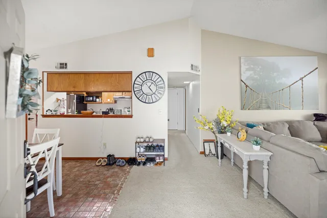 a living room with furniture and a clock on wall