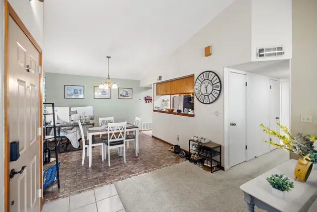 a view of a dining room and livingroom with furniture wooden floor and a clock