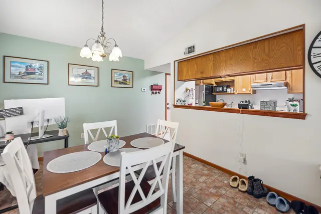 a dining room with furniture a chandelier and wooden floor