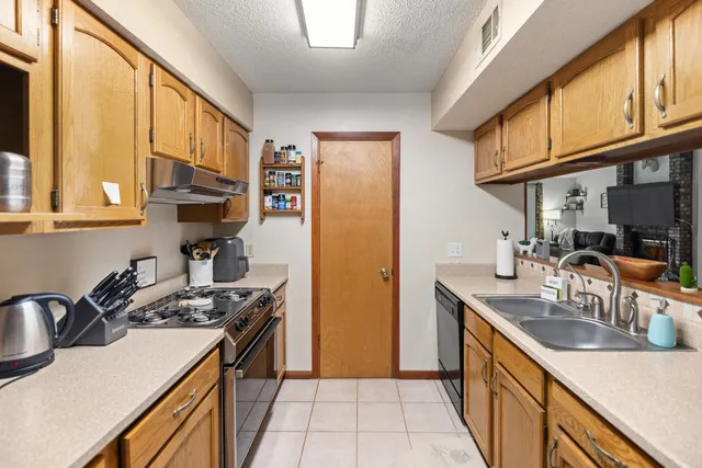 a kitchen with stainless steel appliances granite countertop a sink a stove and a refrigerator